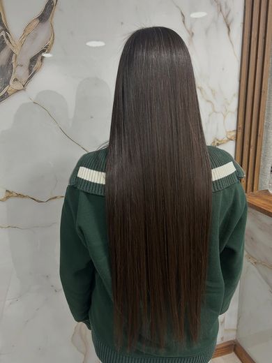 Después del progresivo: pelo castaño oscuro muy largo, lacio y brillante, contra la pared de mármol