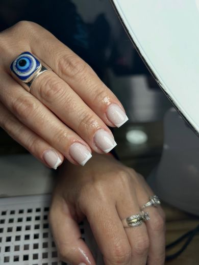 Kapping en acrílico: uñas cortas cuadradas con baby boomer, junto a un anillo de ojo turco